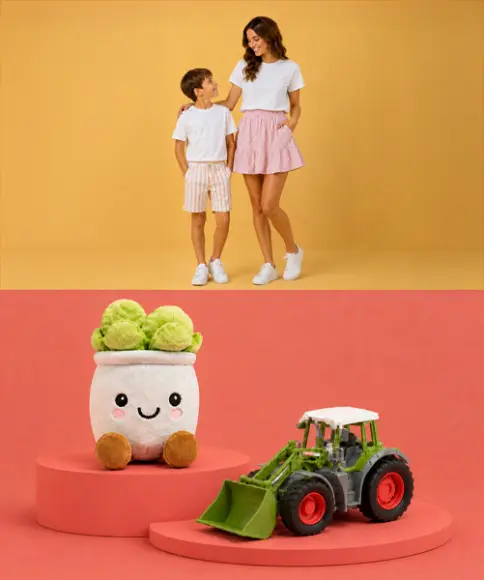 Eine Frau und ein Junge in lässigen Outfits stehen zusammen, darunter sind ein Plüsch‑Brokkoli und ein grüner Spielzeugtraktor auf roten Podesten präsentiert.